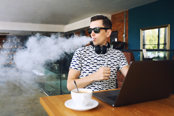 A man wearing sunglasses vaping zero nicotine vapes